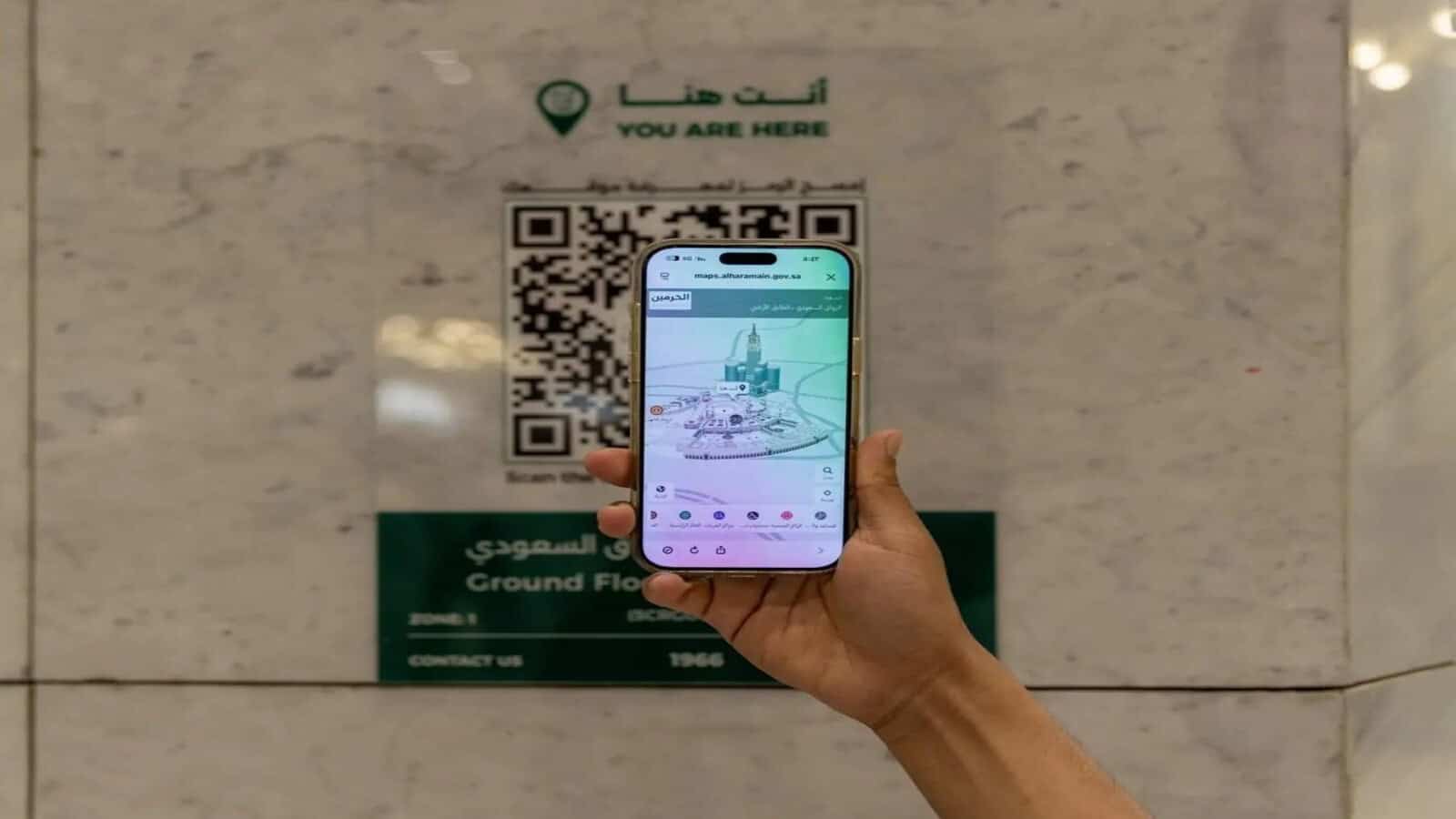 Person scanning a digital wayfinding map on a smartphone at the Grand Mosque and Prophet’s Mosque.