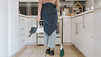 An image of a person cleaning a kitchen, highlighting regulatory actions on unlicensed domestic worker re.
