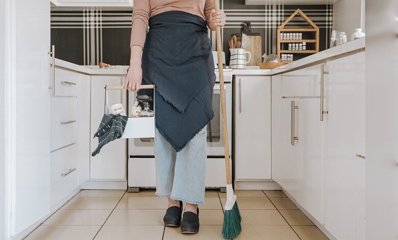 An image of a person cleaning a kitchen, highlighting regulatory actions on unlicensed domestic worker re.