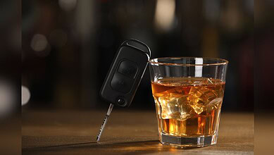 Image shows a car key and a glass of whiskey, emphasizing the crackdown on drunk driving by Hyderabad traffic police.