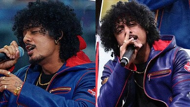 Hanumankind singing into a microphone during a live performance.