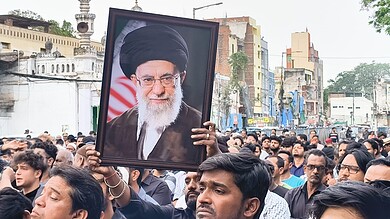 A protester holds a portrait of Ayatollah Ali Khamenei during a rally in Hyderabad following reports of his death.