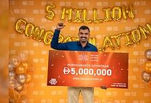 Indian expat Murugananth Govinthan holds cheque after winning Dh 5 million UAE Lottery