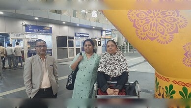 Indian woman with family at airport after reunion, smiling and happy to be back home.