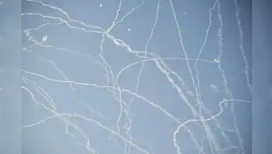 Military jets and missile trails in the sky during Iran's 12-day war.