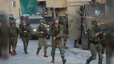 Israeli forces move with armoured vehicles during a military raid in a West Bank town.