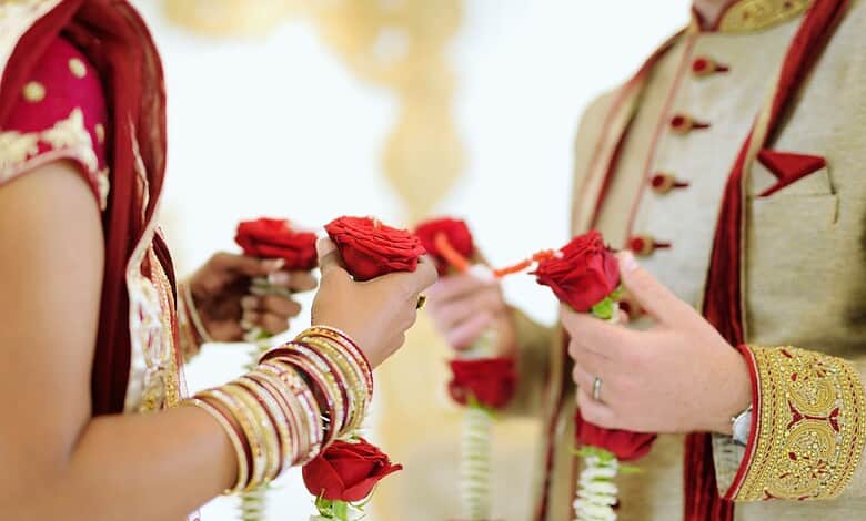 Close-up of bride and groom exchanging floral garlands during wedding ceremony in Hyderabad.
