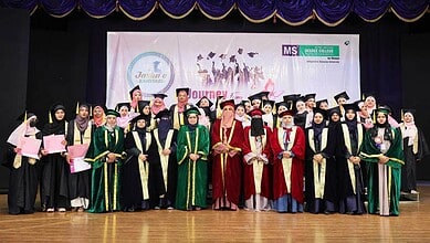 Group of women graduates in caps and gowns at MS Degree College for Women graduation event.