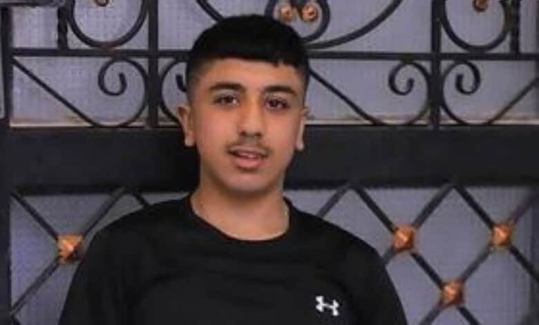 The image of Palestinian teenager Jad Jadallah standing in front of a metal gate.