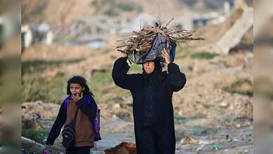 Child carrying firewood in Gaza amid conflict, illustrating humanitarian issues in the West Bank.