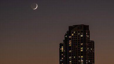 Crescent moon over Hyderabad skyline during Ramzan moon sighting meeting.