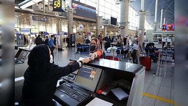 Passengers queue at Tehran Imam Khomeini International Airport amid travel concerns.