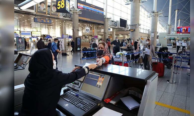 Passengers queue at Tehran Imam Khomeini International Airport amid travel concerns.