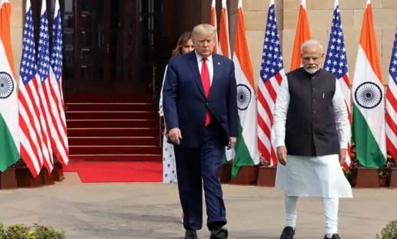 Donald Trump and PM Modi walking past flags during diplomatic discussions.