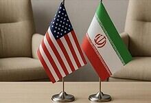 Flags of the United States and Iran placed side by side during a meeting.