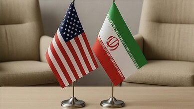 Flags of the United States and Iran placed side by side during a meeting.
