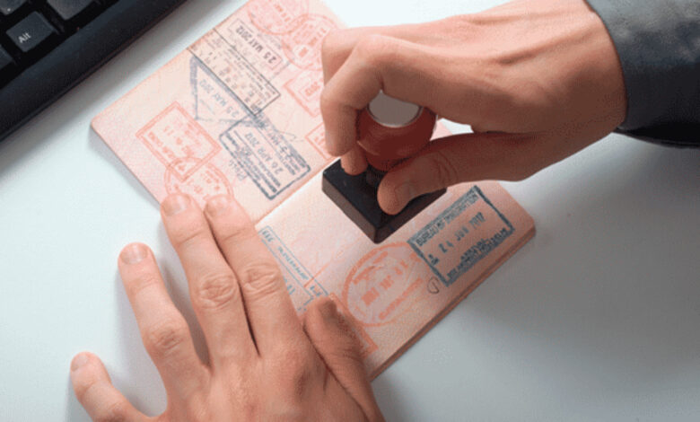 Close-up of a passport being stamped with visa approval.