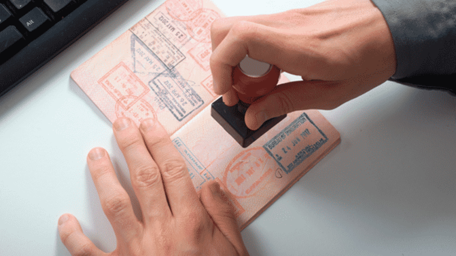 Close-up of a passport being stamped with visa approval.