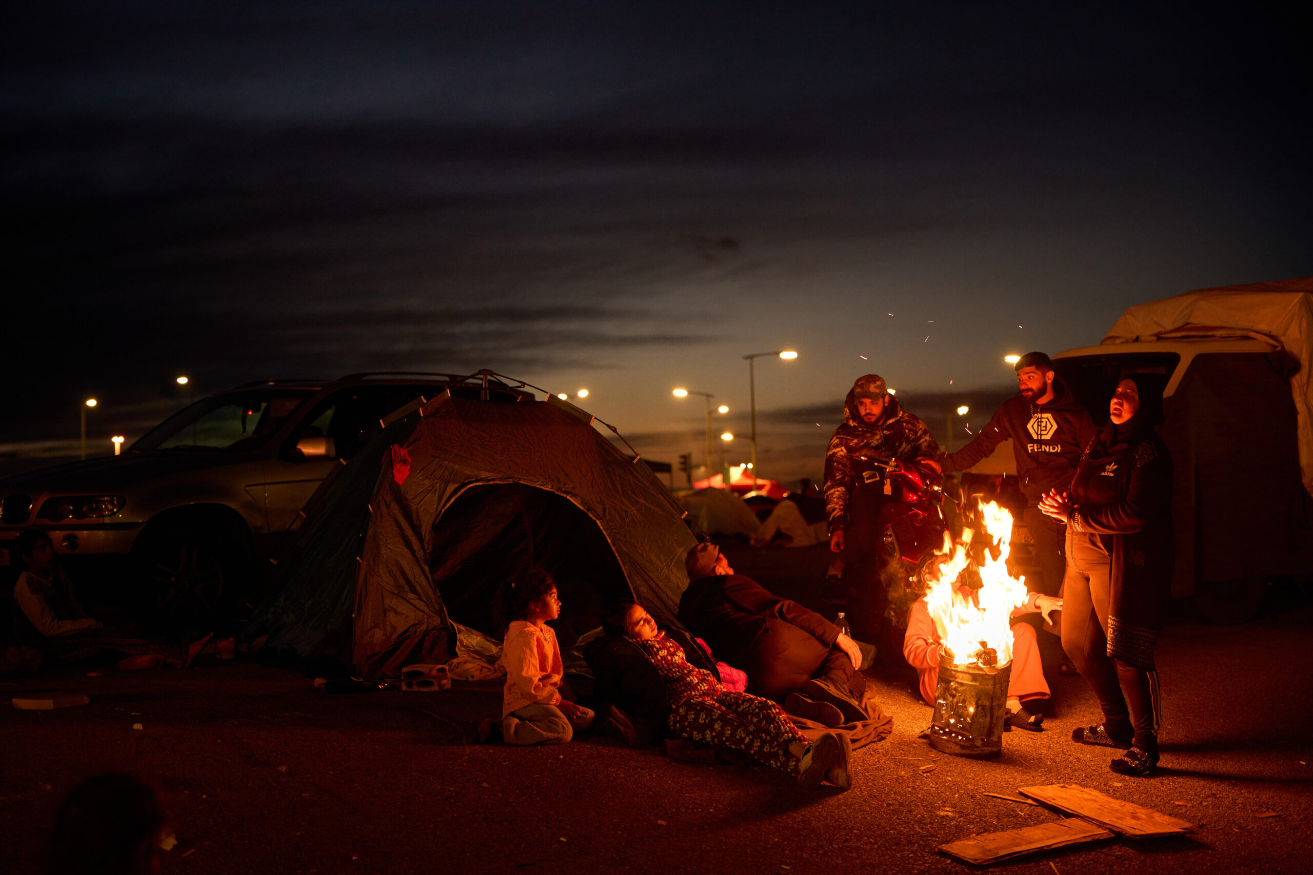 Members of a family, who fled Israeli strikes in southern Lebanon, sit around a bonfire outside a tent used as a shelter in Beirut, Lebanon, Wednesday, March 25, 2026. AP/PTI(AP03_26_2026_000313B)