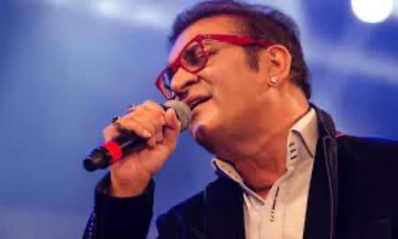 Abhijeet Bhattacharya singing passionately at a concert, seeking government assistance for his stranded s.