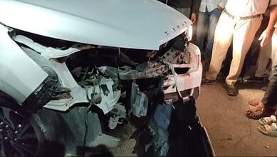 Damaged white car after collision with divider in Hyderabad's Bahadurpura, injuring four.