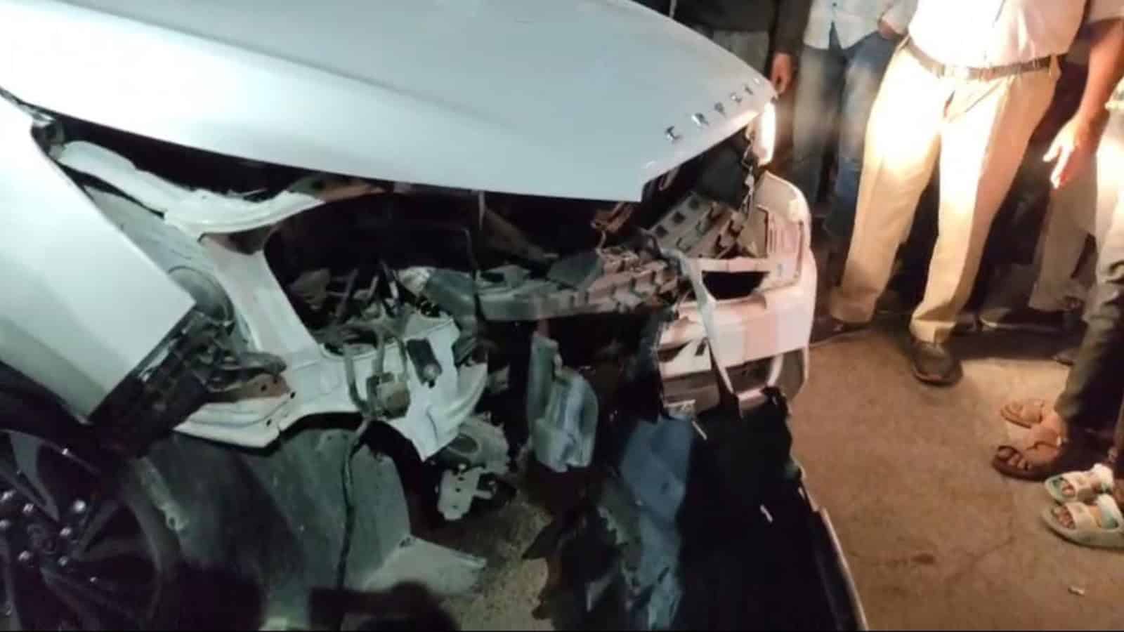 Damaged white car after collision with divider in Hyderabad's Bahadurpura, injuring four.