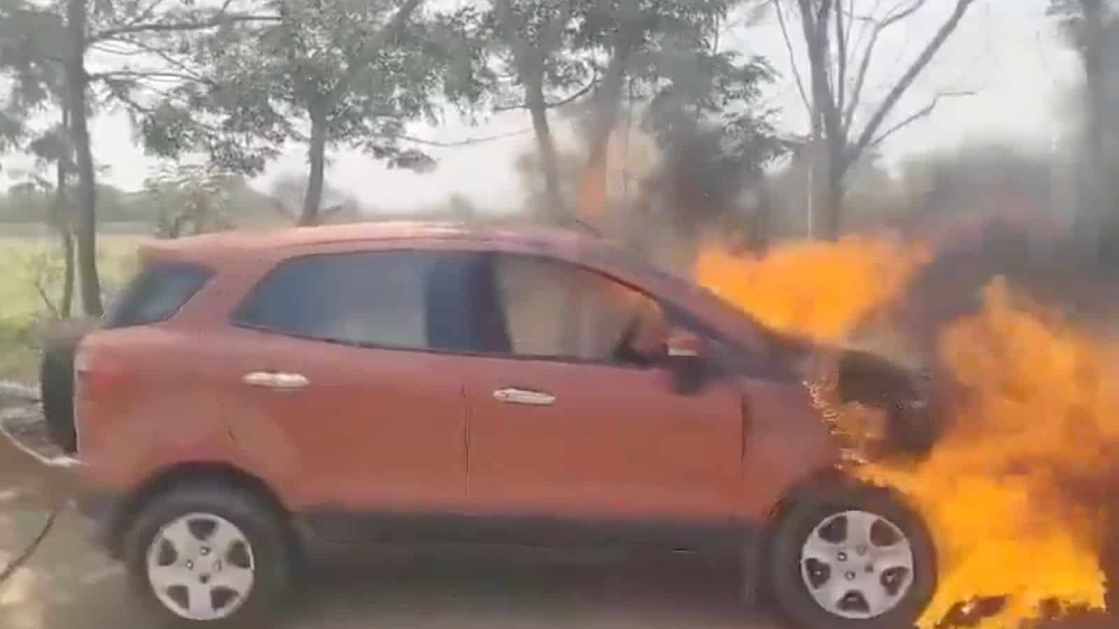 Car on fire during an accident, with flames and smoke.