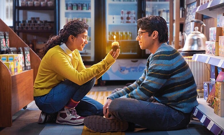 Young woman and man sitting on the floor in a store, sharing a moment of connection.