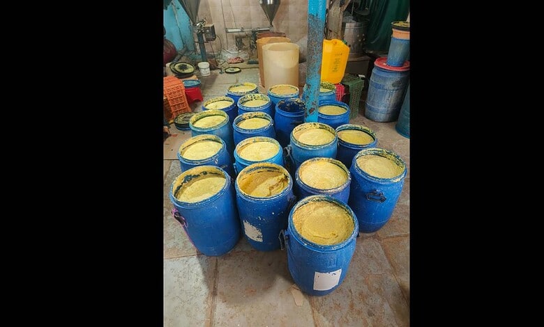 Blue barrels filled with seized adulterated ginger garlic paste in a storage area.