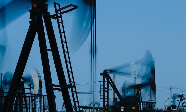 Oil pump jacks at work in an oilfield during daytime.