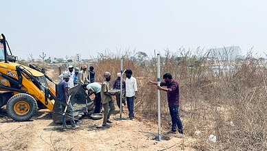 Construction workers installing Hydraa fences on 11-acre land in Kondapur, Hyderabad.