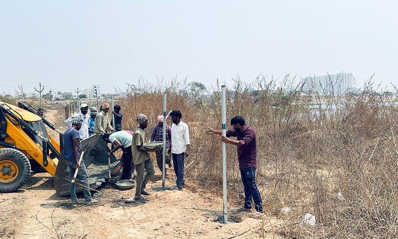 Construction workers installing Hydraa fences on 11-acre land in Kondapur, Hyderabad.