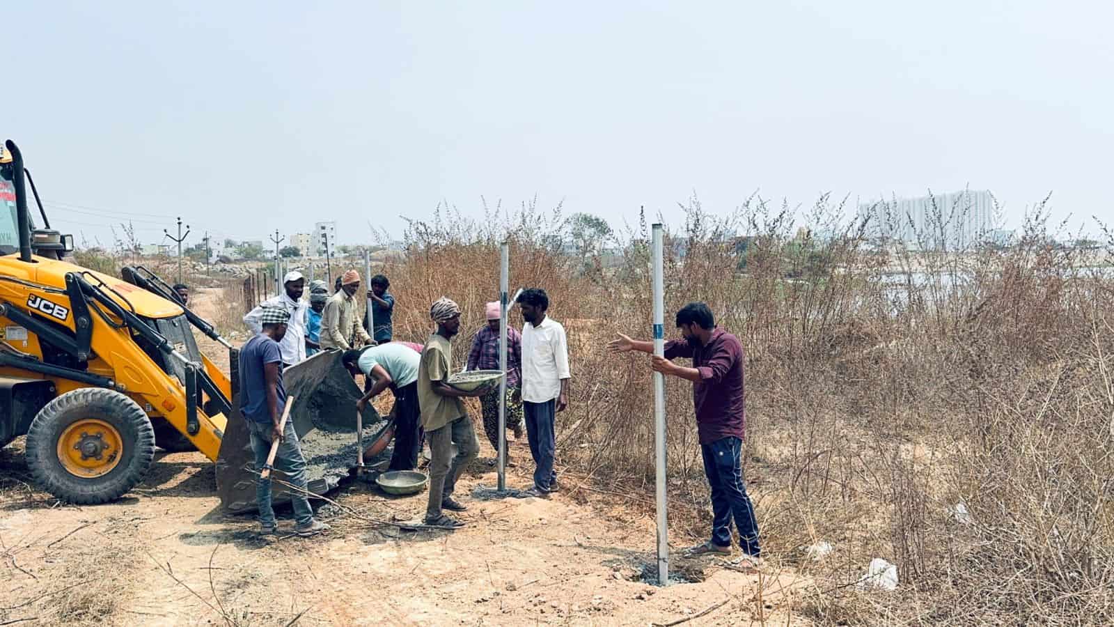 Construction workers installing Hydraa fences on 11-acre land in Kondapur, Hyderabad.