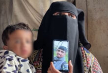 Holding her grandson Jawad, Rana shows a picture of Osama Abu Nassar, both of whom were detained by Israeli forces.