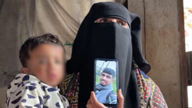 Holding her grandson Jawad, Rana shows a picture of Osama Abu Nassar, both of whom were detained by Israeli forces.