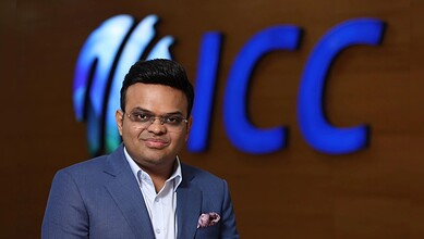 Man in formal suit standing in front of ICC logo, celebrating record-breaking T20 World Cup viewership.