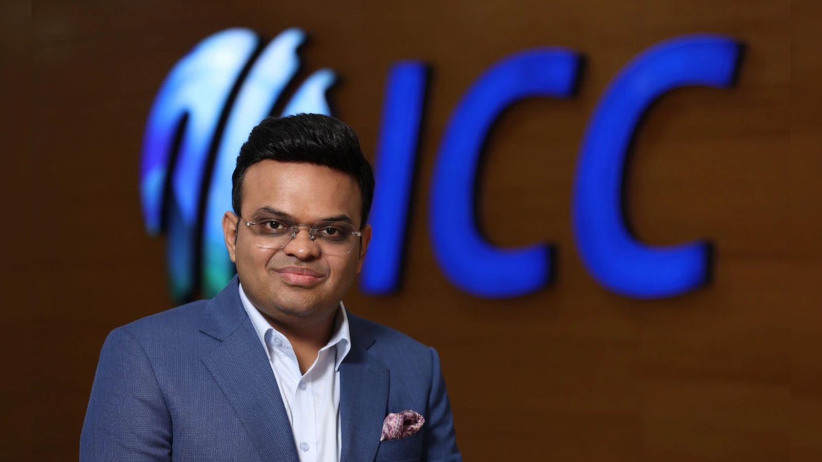 Man in formal suit standing in front of ICC logo, celebrating record-breaking T20 World Cup viewership.