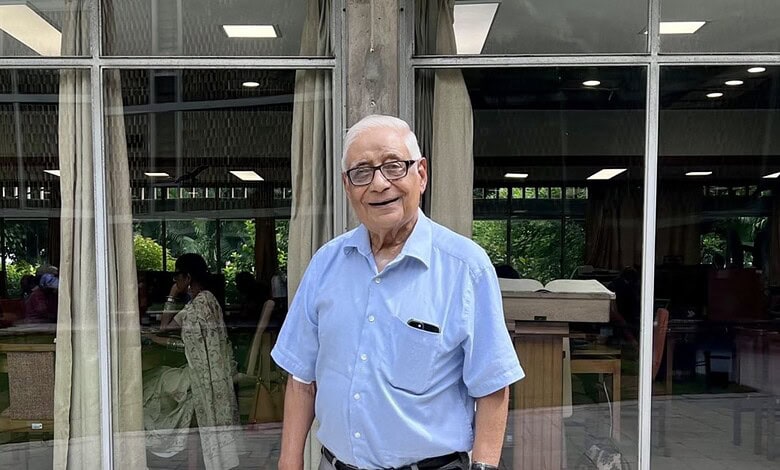 HK Dua, renowned journalist and diplomat, smiling in a light blue shirt at a public event.
