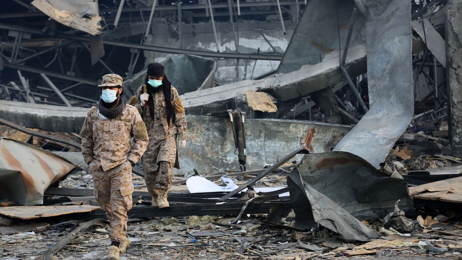 Soldiers inspecting destruction after explosion in urban area.
