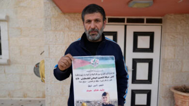 Khalid Ahmad holds a poster of his 17-year-old son, Walid Ahmad, who died in an Israeli prison, that read in Arabic, The hero prisoner Martyr, mercy and eternity for our righteous Martyrs.