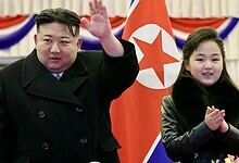 North Korean leader Kim Jong-un and his daughter attending a missile test event with North Korean flags i.