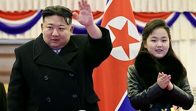North Korean leader Kim Jong-un and his daughter attending a missile test event with North Korean flags i.