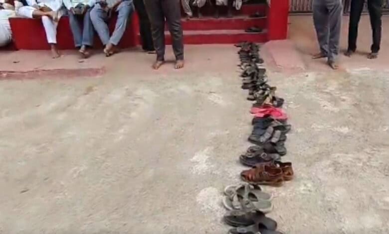 Queue of residents leaving footwear in line for LPG cylinders in Bhainsa, Telangana.