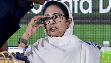 Mamata Banerjee adjusting her glasses at a political event, highlighting her active engagement in regiona.