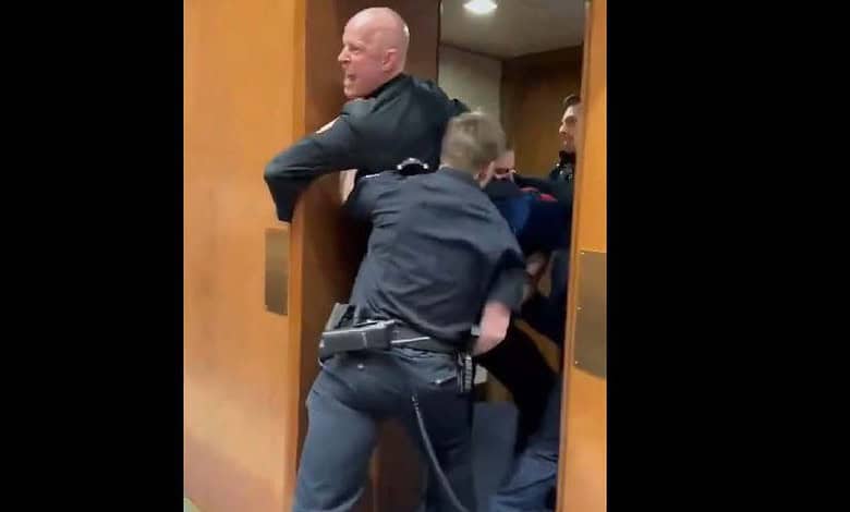 A former US Marine is escorted by police while protesting