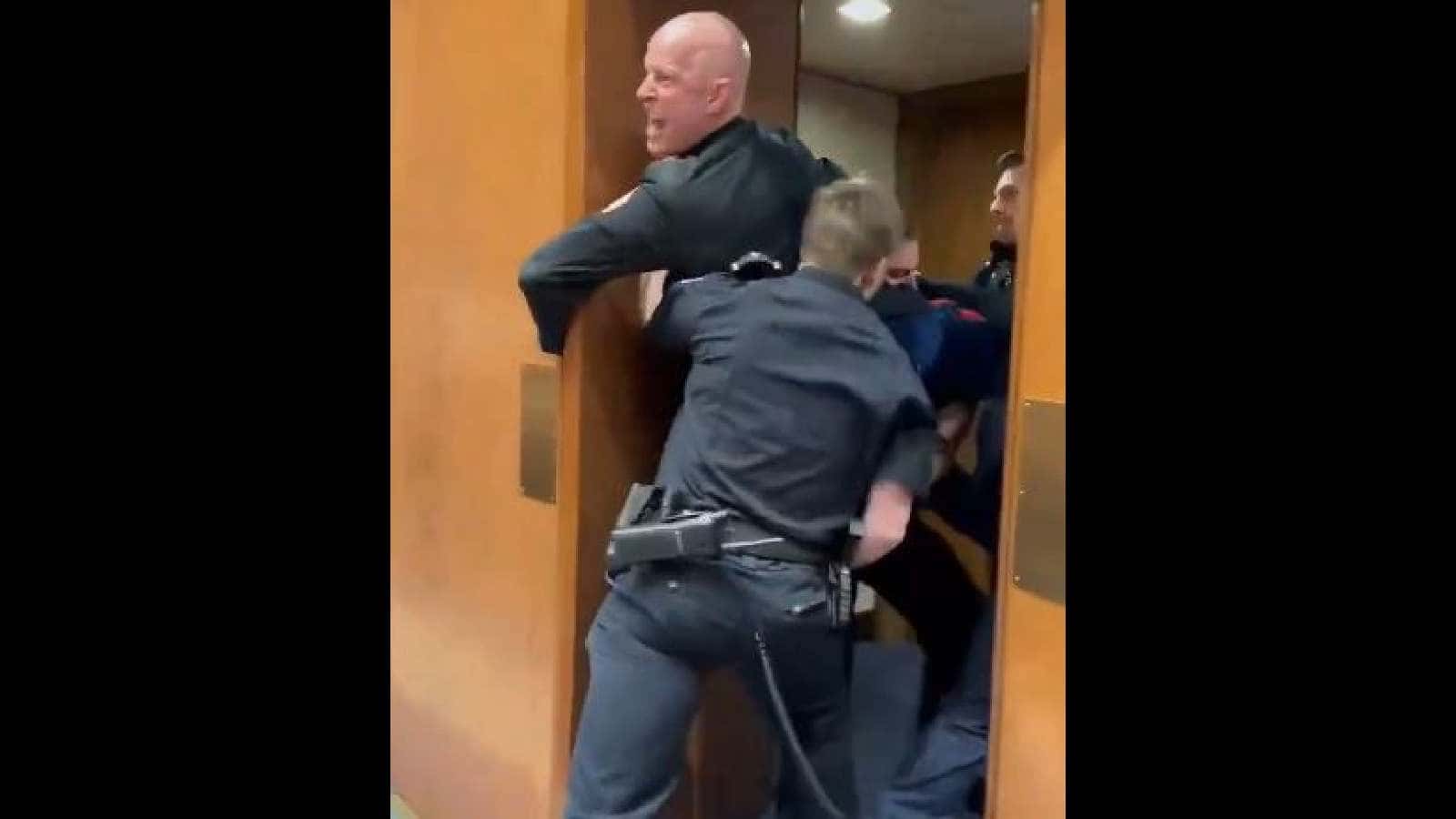 A former US Marine is escorted by police while protesting