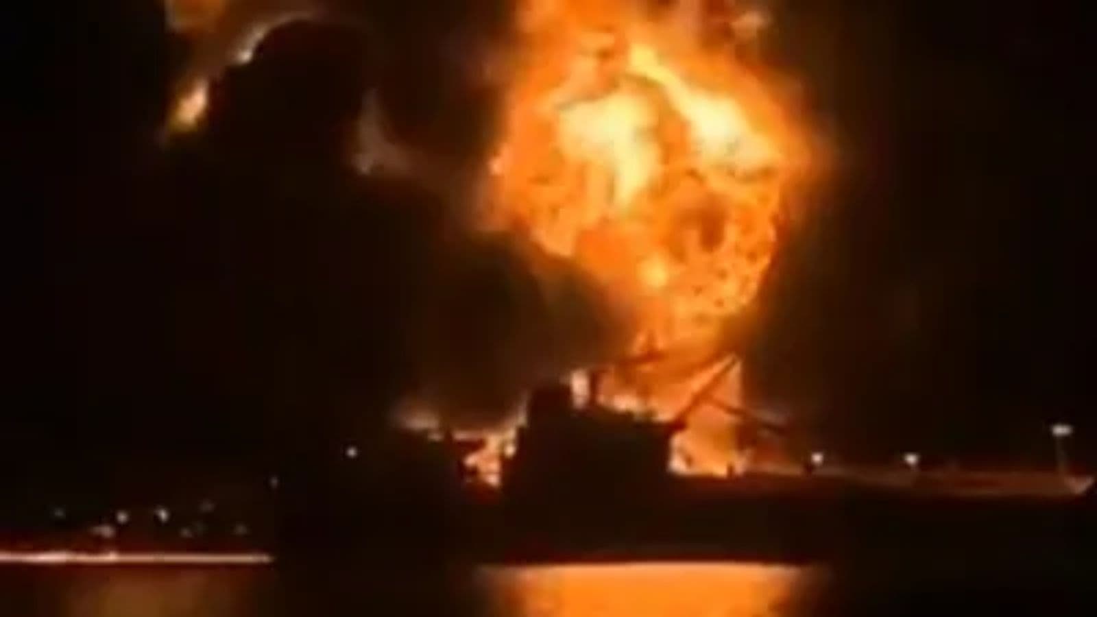 Oil tanker on fire after attack at sea, with large flames and thick black smoke rising.