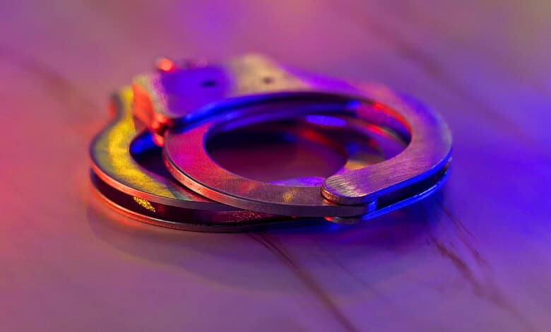 Handcuffs on a wooden surface, representing legal action against public nuisance offences.