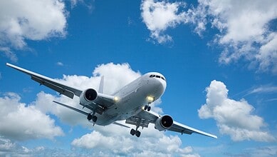 Commercial airplane flying in clear sky, promoting mystery flights for Palestinians to South Africa.