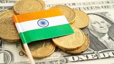 India flag on coins and dollar bills, illustrating currency exchange and economic fluctuations.